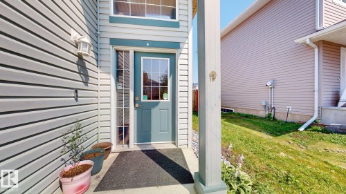 Exterior featuring horizontal siding, a light blue door with window inserts, and white window trim - 7848 7 Avenue Sw, Edmonton, AB - Outdoor With Exterior