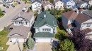 Two-story residence featuring a green shingle roof, light-colored siding, and an attached two-car garage with a paved driveway - 7848 7 Avenue Sw, Edmonton, AB 