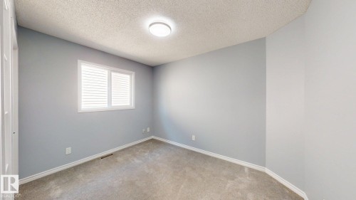 Recessed window with white plantation shutters, light gray wall finish, and neutral carpet flooring - 7848 7 Avenue Sw, Edmonton, AB - Indoor Photo Showing Other Room