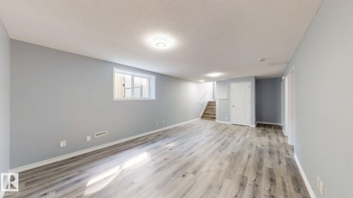 Expansive backyard with a wooden fence, mature evergreen tree, and a built-in fire pit - 7848 7 Avenue Sw, Edmonton, AB - Outdoor With Deck Patio Veranda