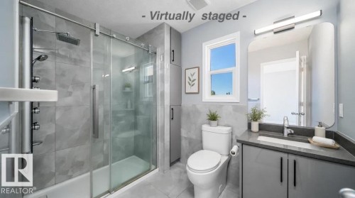 Shower featuring a sliding glass door, rain shower head, and body spray system - 7848 7 Avenue Sw, Edmonton, AB 