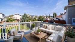 Expansive outdoor deck with blue-painted wood flooring, white railings, and string lighting - 