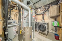 Utility area with exposed ceiling joists, ductwork, and a hot water tank - 