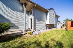 Siding exterior with a covered entry, concrete pathway, and gravel landscaping - 