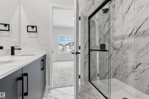 Dual vanity with quartz countertops, matte black fixtures, and integrated sinks - 8815 181 Avenue Nw, Edmonton, AB - Indoor Photo Showing Bathroom