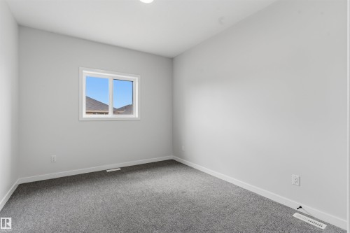 Neutral wall finishes, contemporary window, and soft carpet flooring - 8815 181 Avenue Nw, Edmonton, AB - Indoor Photo Showing Other Room