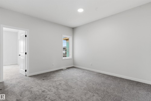 Recessed ceiling light, single window, white interior door with dark hardware, light gray wall paint, and gray carpet - 8815 181 Avenue Nw, Edmonton, AB - Indoor Photo Showing Other Room