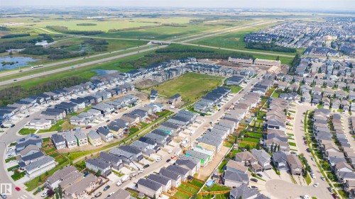 Residential development featuring diverse architectural styles, visible green spaces, and proximity to highway infrastructure - 8815 181 Avenue Nw, Edmonton, AB - Outdoor With View