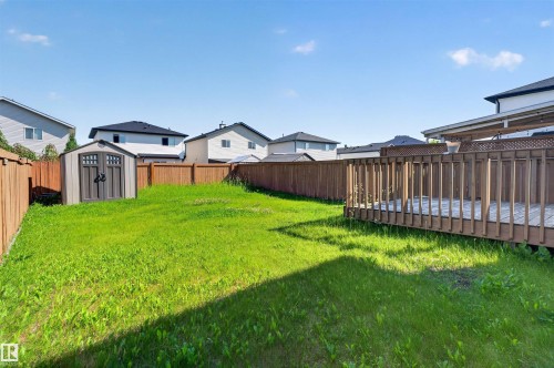 Expansive backyard with a wood privacy fence, a storage shed, and a wood deck featuring a lattice top - 1816 36 Avenue Nw, Edmonton, AB - Outdoor With Backyard