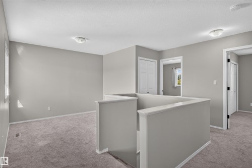 Carpeted landing with neutral wall paint and white trim - 1816 36 Avenue Nw, Edmonton, AB - Indoor Photo Showing Other Room