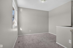Neutral tone wall paint, textured carpet flooring, window with blinds, white trim, and ceiling-mounted light fixture - 