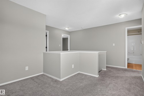 Carpeted landing with neutral wall paint, white trim, and flush mount lighting - 1816 36 Avenue Nw, Edmonton, AB - Indoor Photo Showing Other Room