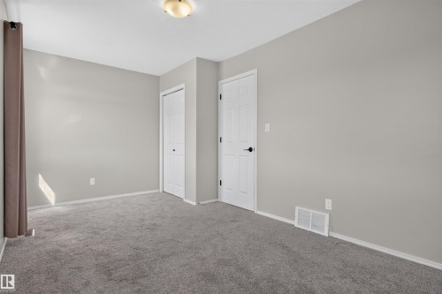 Neutral-toned carpet flooring, light gray wall paint, and white trim - 1816 36 Avenue Nw, Edmonton, AB - Indoor Photo Showing Other Room