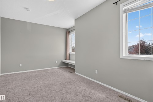 Plush carpeting throughout, light gray wall paint, and a built-in window bench - 1816 36 Avenue Nw, Edmonton, AB - Indoor Photo Showing Other Room
