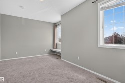 Plush carpeting throughout, light gray wall paint, and a built-in window bench - 