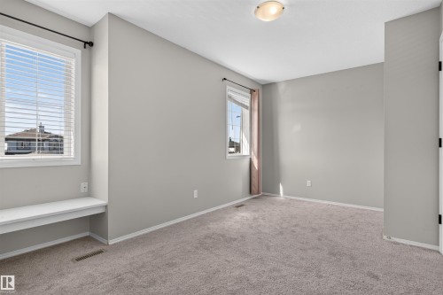 Window with horizontal blinds, built-in window bench, ceiling-mounted light fixture, and neutral-toned wall-to-wall carpeting - 1816 36 Avenue Nw, Edmonton, AB - Indoor Photo Showing Other Room