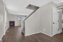 Wood-finish flooring, staircase with carpeted treads, built-in fireplace with a tiled surround, recessed lighting, and white paneled interior doors - 1816 36 Avenue Nw, Edmonton, AB  - Indoor Photo Showing Other Room With Fireplace 