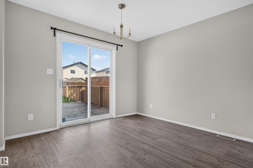 Sliding glass door access to an outdoor patio with wood privacy fencing - 1816 36 Avenue Nw, Edmonton, AB - Indoor Photo Showing Other Room