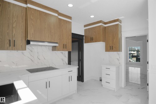 Sleek kitchen with wood-finish upper cabinetry, white lower cabinetry, and a built-in cooktop - 6823 18 Avenue Sw, Edmonton, AB - Indoor Photo Showing Kitchen