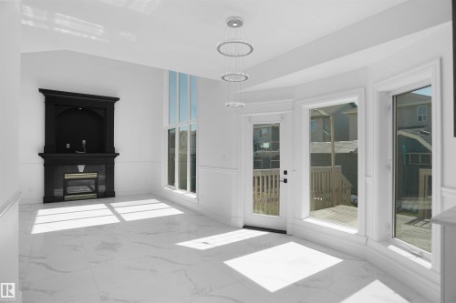 High ceilings, large windows, French door, built-in fireplace with mantel, and marble-finish flooring - 6823 18 Avenue Sw, Edmonton, AB - 