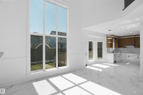 High ceilings, large windows, white tile flooring, white wainscoting, and a kitchen with two-tone cabinetry - 6823 18 Avenue Sw, Edmonton, AB - Indoor