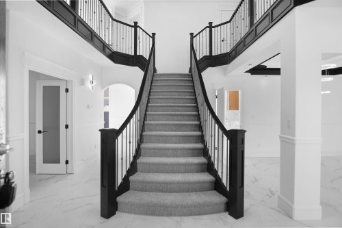 Curved staircase with carpeted treads and black railings - 6823 18 Avenue Sw, Edmonton, AB - Indoor Photo Showing Other Room