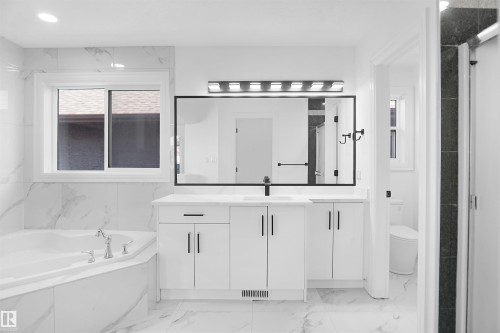 White floating vanity with dual sinks, a large framed mirror, and a modern light fixture - 6823 18 Avenue Sw, Edmonton, AB - Indoor Photo Showing Bathroom
