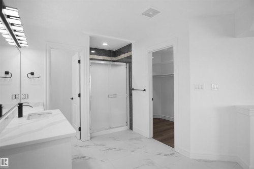 Double vanity with integrated sinks, matte black fixtures, and a modern light fixture - 6823 18 Avenue Sw, Edmonton, AB - Indoor Photo Showing Other Room