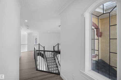 Wood-finish flooring, recessed lighting, crown molding, and wrought iron balusters - 6823 18 Avenue Sw, Edmonton, AB - Indoor Photo Showing Other Room