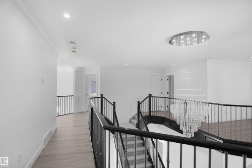 Grand staircase with dark wood handrails and wrought iron balusters - 6823 18 Avenue Sw, Edmonton, AB - Indoor Photo Showing Other Room
