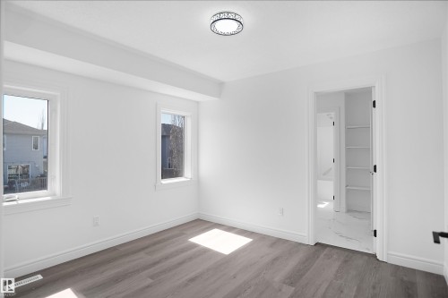 Recessed lighting, wood-finish flooring, white walls, and built-in shelving - 6823 18 Avenue Sw, Edmonton, AB - Indoor Photo Showing Other Room