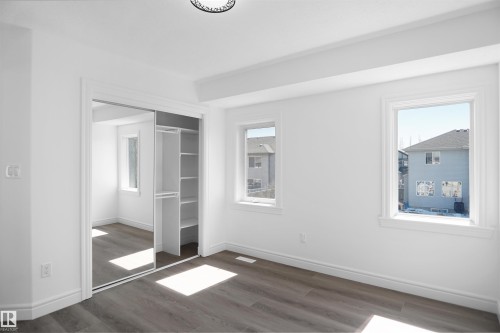 Recessed ceiling, wood-finish flooring, white trim, mirrored sliding closet doors, built-in closet shelving - 6823 18 Avenue Sw, Edmonton, AB - Indoor Photo Showing Other Room