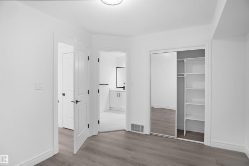 Wood-finish flooring, white walls, and a contemporary ceiling light fixture - 6823 18 Avenue Sw, Edmonton, AB - Indoor Photo Showing Other Room