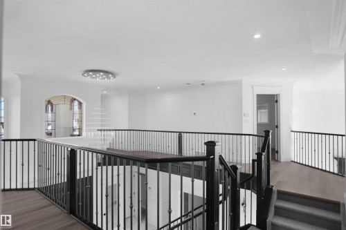 Open concept upper level featuring wood-finish flooring, wrought iron balusters, recessed lighting, and a contemporary chandelier - 6823 18 Avenue Sw, Edmonton, AB - Indoor Photo Showing Other Room
