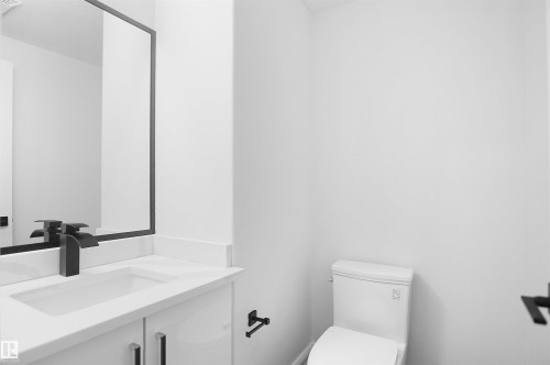 White vanity with a rectangular undermount sink, a matte black faucet, and a framed mirror - 6823 18 Avenue Sw, Edmonton, AB - Indoor Photo Showing Bathroom