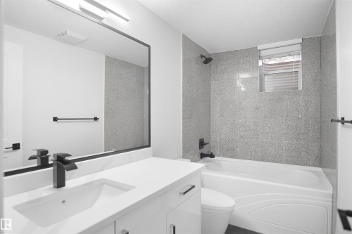 White vanity with a rectangular undermount sink and matte black faucet - 6823 18 Avenue Sw, Edmonton, AB - Indoor Photo Showing Bathroom