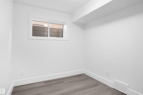 Recessed window, wood-finish flooring, white walls, and bright white trim - 6823 18 Avenue Sw, Edmonton, AB - Indoor Photo Showing Other Room