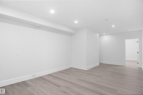 Recessed ceiling lighting, light wood-finish flooring, white wall paint, and white trim - 6823 18 Avenue Sw, Edmonton, AB - Indoor Photo Showing Other Room