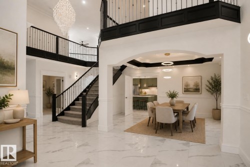 Two-story foyer with a grand staircase and wrought iron railings - 6823 18 Avenue Sw, Edmonton, AB - Indoor