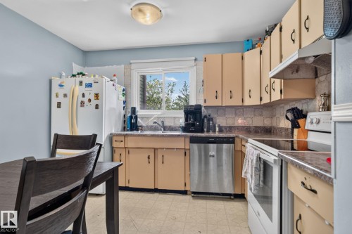 Kitchen featuring a double basin sink, neutral cabinetry, and integrated appliances - 8031 27 Avenue Nw, Edmonton, AB - Indoor Photo Showing Kitchen