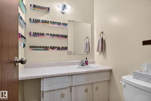 Vanity with an integrated sink, laminate countertop, and built-in cabinetry with decorative hardware - 8031 27 Avenue Nw, Edmonton, AB - Indoor Photo Showing Bathroom