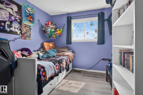 Wood-finish flooring with a single window featuring dark-colored drapes - 8031 27 Avenue Nw, Edmonton, AB - Indoor