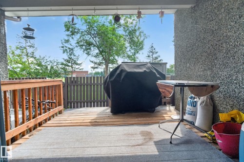Outdoor patio featuring a privacy fence and wood railing - 8031 27 Avenue Nw, Edmonton, AB - Outdoor With Exterior