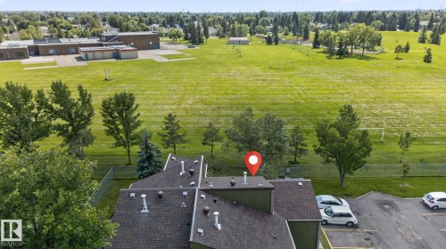 Extensive green space bordering the property, with a distant institutional building - 8031 27 Avenue Nw, Edmonton, AB - Outdoor With View