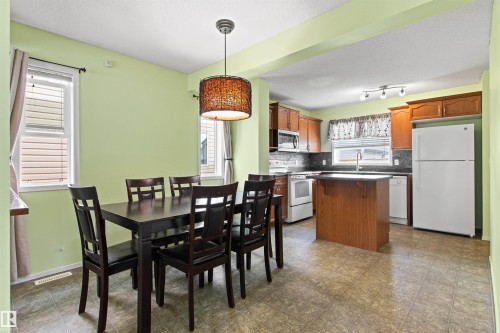 Open-concept dining area with an overhead chandelier - 9118 Scott Crescent Nw, Edmonton, AB - Indoor