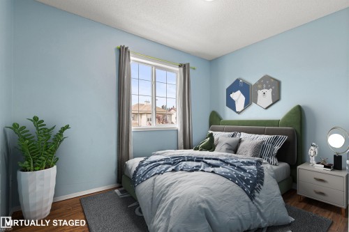 Wood-finish flooring, light blue painted walls, and a window with a multi-pane grid - 9118 Scott Crescent Nw, Edmonton, AB - Indoor Photo Showing Bedroom