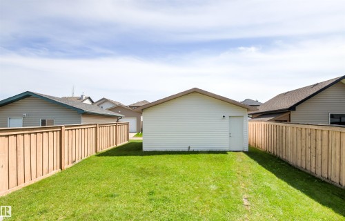 Expansive grassy yard with a detached garage and wood privacy fencing - 9118 Scott Crescent Nw, Edmonton, AB - Outdoor With Exterior