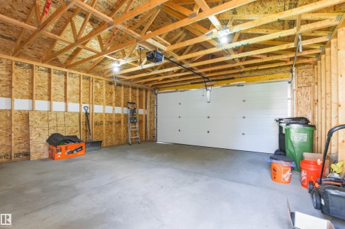 Concrete flooring, exposed wood framing, white garage door, overhead lighting, garage door opener - 9118 Scott Crescent Nw, Edmonton, AB - Indoor Photo Showing Garage