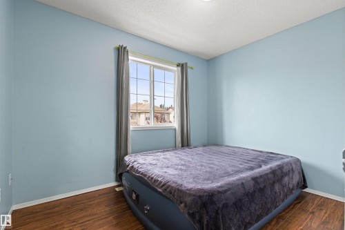 Wood-finish flooring, light blue wall paint, recessed ceiling lighting, and a single window with grids - 9118 Scott Crescent Nw, Edmonton, AB - Indoor Photo Showing Bedroom