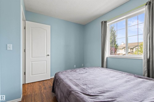 Wood-finish flooring with a light blue wall finish - 9118 Scott Crescent Nw, Edmonton, AB - Indoor Photo Showing Bedroom